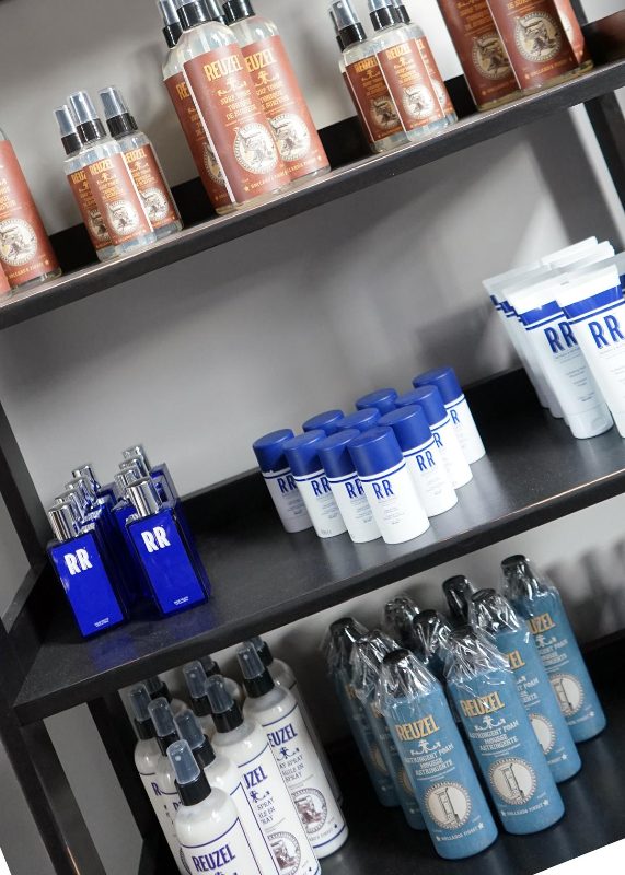 The retail shelf stocked with Reuzel pomade and grooming products