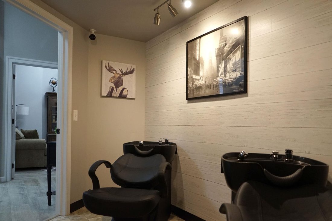 Two shampoo bowls and chairs in the wash room